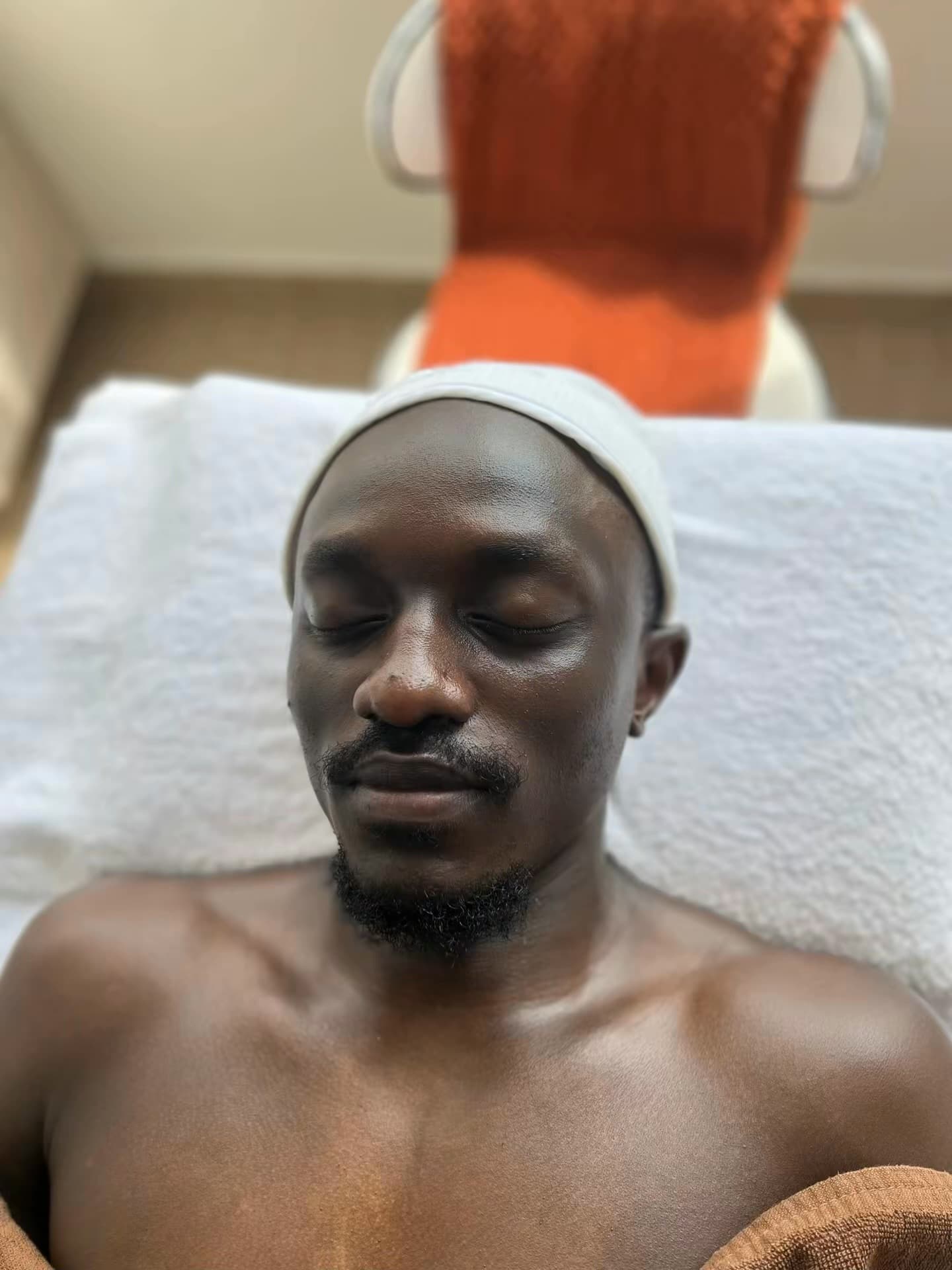 A male client relaxing with his eyes closed during a facial treatment at Skin by Lyze in Nairobi