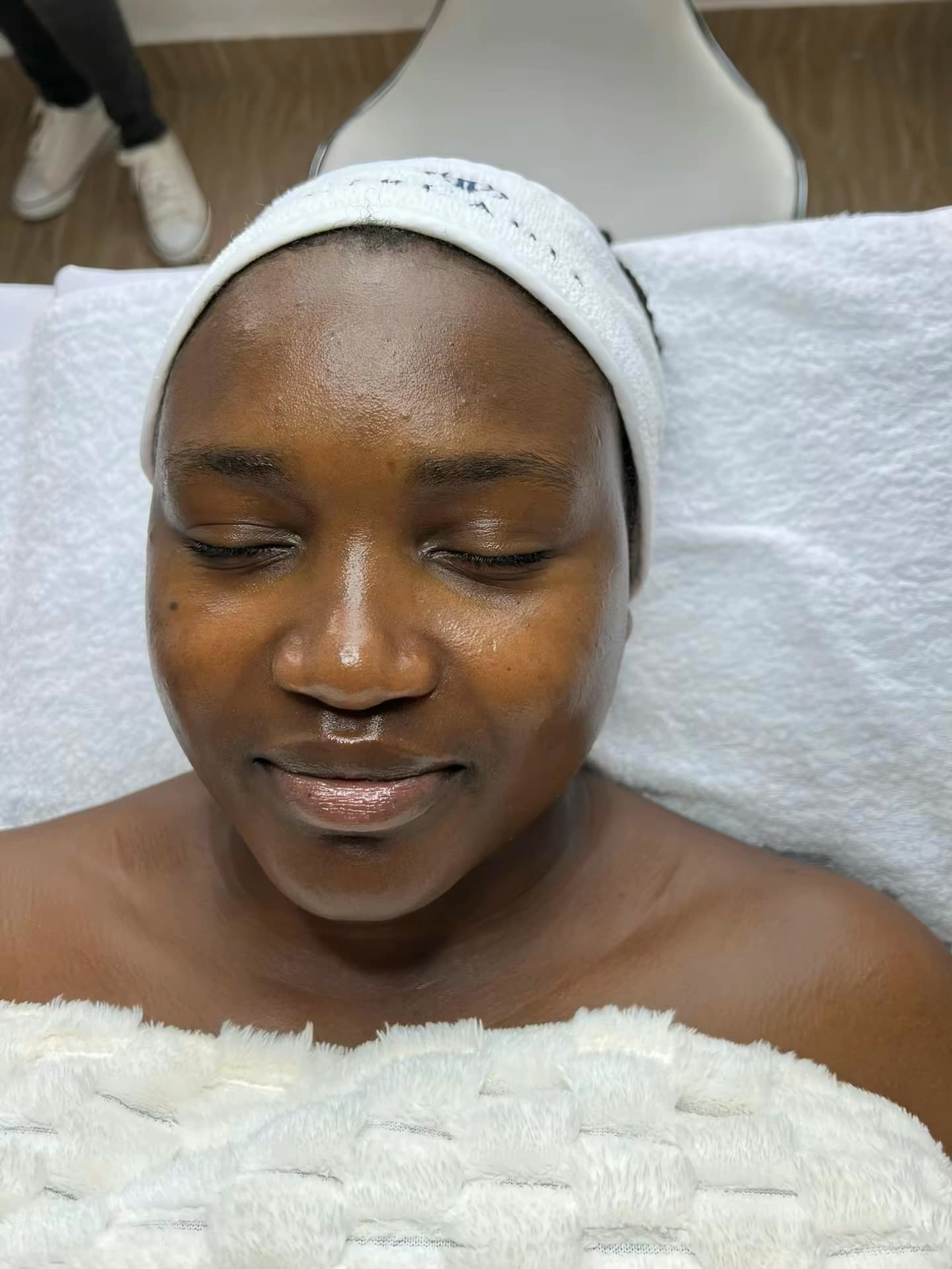 A client with a spa headband resting with her eyes closed during a facial at Skin by Lyze in Nairobi